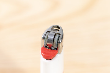 close up of a white lighter on wooden table 