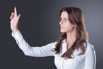 modern successful business woman presses on a virtual button.isolated in the dark