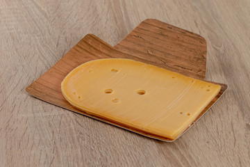 piece of cheese on a wooden board