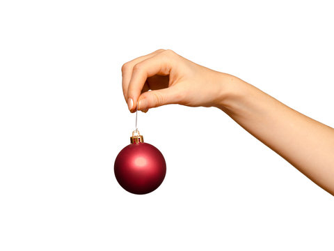 Female hand holding red Christmas decoration, isolated on white