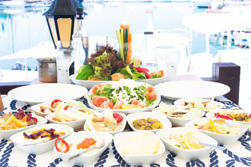 Seafoods, fish, salad and mezes on the table near the sea