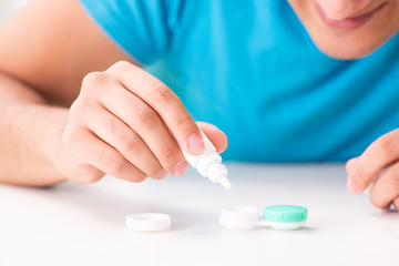 Man trying contact lenses at home