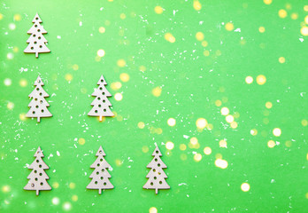 New Year wooden ornaments, top view. Wooden Christmas tree. Green background. Flat lay style.