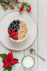 Breakfast, oatmeal with blueberry and raspberry on white bowl. Healthy food