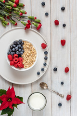 Breakfast, oatmeal with blueberry and raspberry on white bowl. Healthy food