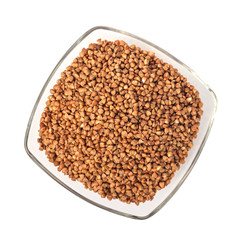 Roasted buckwheat grains in glass bowl isolated on white background