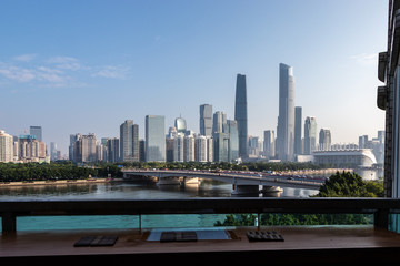 Modern city with skyscrapers. City buildings, a bridge across the river, driving cars on the bridge. High towers of a business center. Modern architecture of buildings.