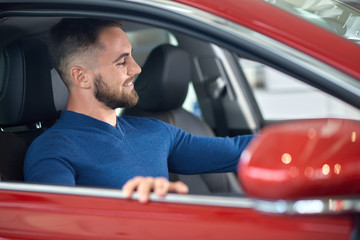 Attractive customer in blue sweater choosing auto in salon.