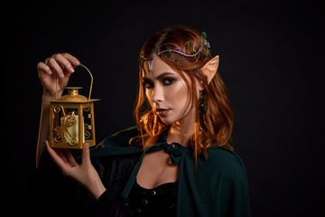 Portrait of charming mystical girl with red hair in cloak. 