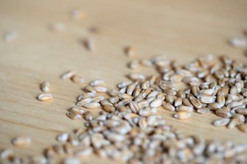 Scattered wheat grains on wooden background close up