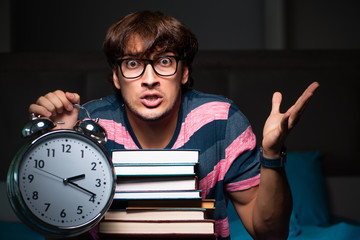 Young handsome student preparing for exams at night