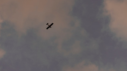 The machine flies high in the evening sky.