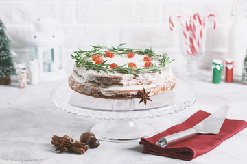 Christmas cake on glass stand decorated with rosemary dried berries