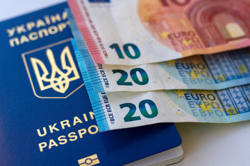 Passports of citizens of Ukraine for traveling abroad and three Euro notes. Concept on the theme of travel on low-cost aircraft. Cheap flights Ukrainians in Europe.