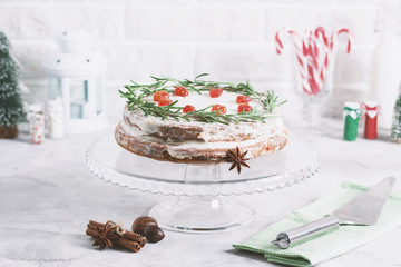 Christmas cake on glass stand decorated with rosemary dried berries