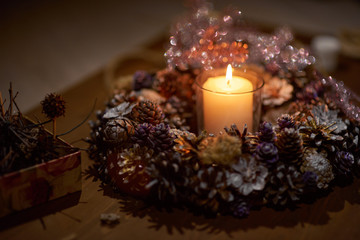 Advent decoration, wreath, candle. In the dark a candle in a beautiful decorative wreath is burning.