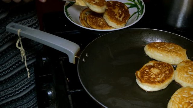 Homemade baking. Cooking fried fresh delicious pancakes in a pan in boiling oil. Pancakes - a traditional breakfast in Russian, Ukrainian cuisine and kitchen of other nations of the world.