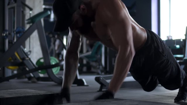 Muscular man doing push up at gym