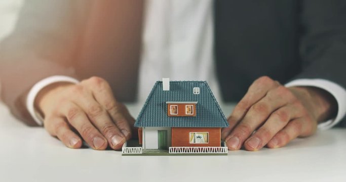 real estate agent showing model of the new house