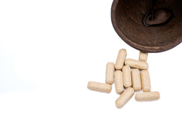Concept for whom the bell tolls: old antique bell and medical pills isolated on white background.