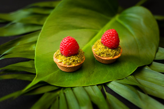 Delicious tartlets filled with fruits isoleted on natural green leaf