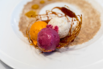 Colorful scoops of ice cream decorated with caramel and sugar