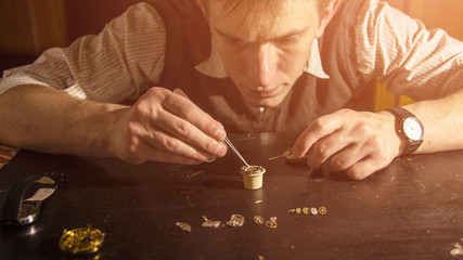 The watchmaker is repairing the mechanical watches in his workshop
