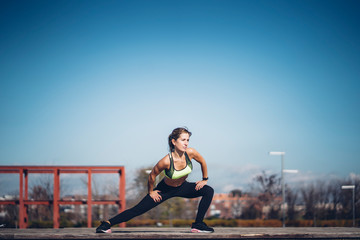 Pretty woman performs exercising outdoors in the park.