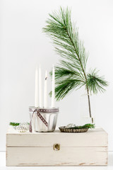 Four Christmas Advent candles and holiday decorations around on white background. Selective focus..