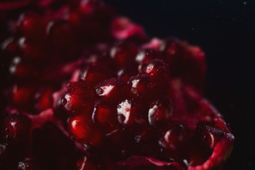 Delicious, juicy, ripe pomegranate in drops and splashes of water