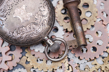 Fototapeta na wymiar Panta rhei concept: antique pocket watch, old vintage key and hour metallic gears on natural stone background.