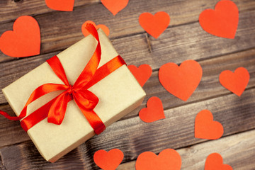 Gift box with red hearts on wooden top view background