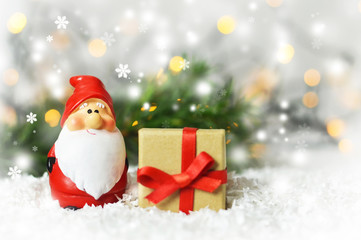 Santa Claus and Christmas gift on snowy background with copy space. Christmas and New Year greeting card concept