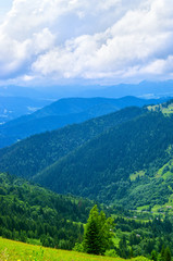 Landscape from height to mountain slopes, blue distance, meadow. Ukraine The Carpathians.