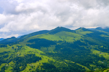 Fototapeta premium aerial view on mountain slopes with houses. Carpathians Ukraine
