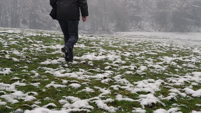 Man goes through snowy meadow - (4K)
