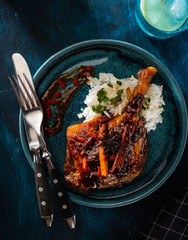 Duck leg confit with rice and goji berries. Traditional french cuisine. View from above.