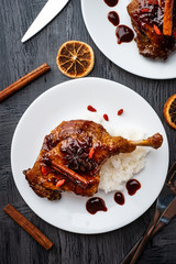 Duck leg confit with rice and goji berries. Traditional french cuisine. View from above.