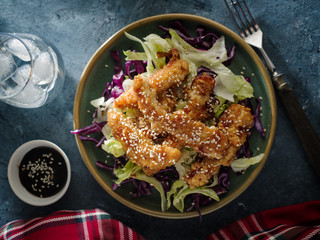Salad with warm glazing chicken, sprinkled with sesame seeds. Chinese cuisine. Asian culture