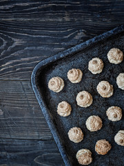Fototapeta na wymiar Christmas coconut meringue cookies on baking pan. Overhead shot with copy space.