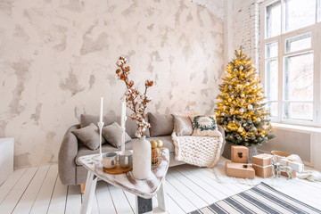 Light living room with Christmas tree. Comfortable sofa, high large Windows. Light white brick wall.
