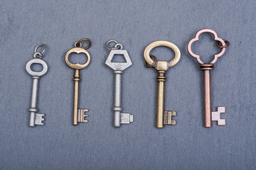 Old vintage metallic keys an natural stone background