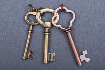 Old vintage metallic keys an natural stone background