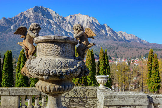 Cantacuzino Palace in Busteni mountain resort , Prahova ,Romania. Outdoor sculpture in the garden and Caraiman mountain at the background.