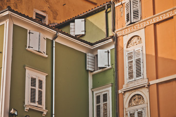 Beautiful colored old houses with stylish windows in the city of Piran. Architecture in the Adriatic. Travel to Slovenia