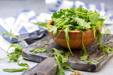 Arugula leaves for salad in a wooden bowl.