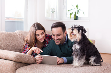 Happy couple with dog on sofa