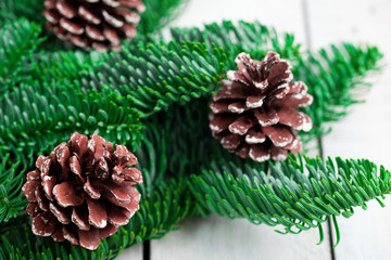 Christmas tree branches on white wooden desk. Flat lay space for text.