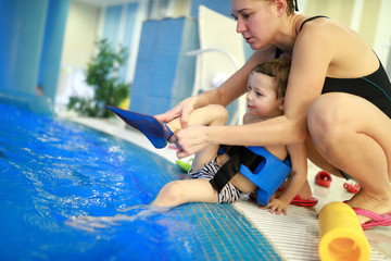 Mother puts flippers on her son feet © Arkady Chubykin
