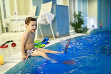 Child sitting on edge of pool
